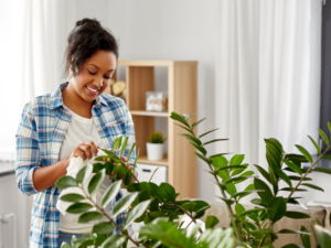 Jeune femme rassereinée par ses plantees d'appartement